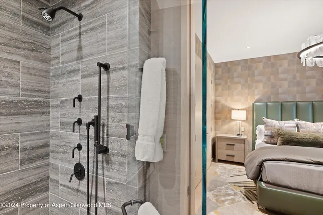 a spacious bedroom with a bed and a chandelier