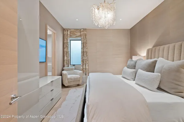 a spacious bedroom with a bed and a chandelier
