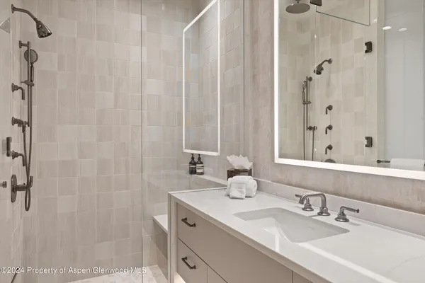 a bathroom with a shower sink and mirror