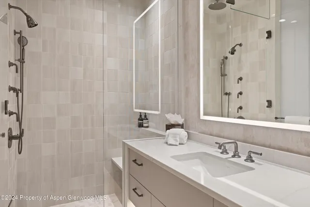 a bathroom with a shower sink and mirror