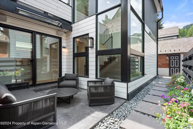 a view of a patio with couches table and chairs and potted plants