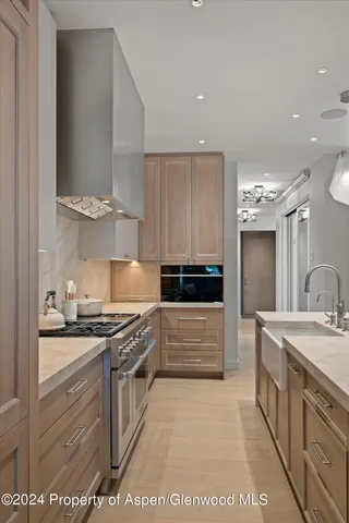 a kitchen with stainless steel appliances granite countertop a stove a sink and a refrigerator