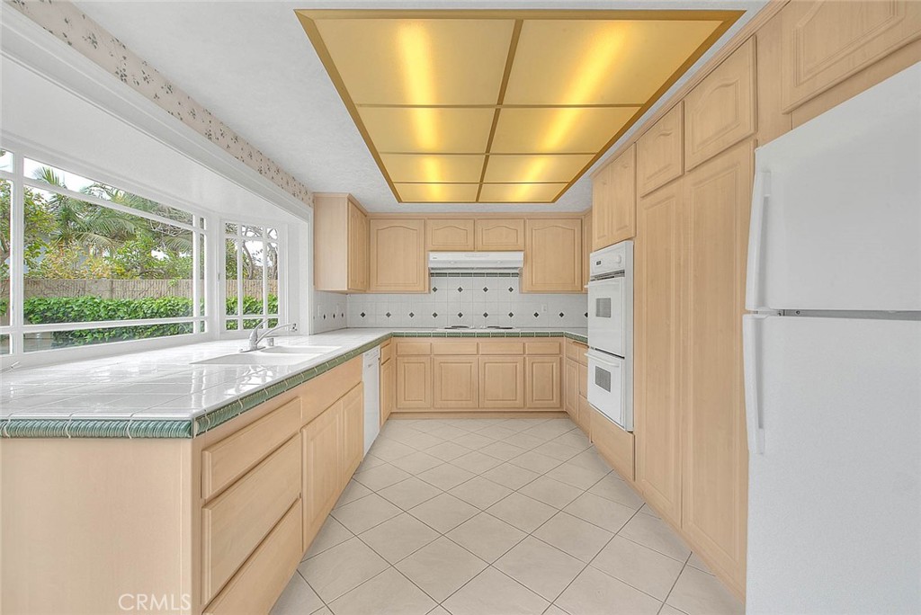 4408 Elder Avenue Seal Beach, CA 90740 - Photo 21 of 73 a large white kitchen with a sink and large window