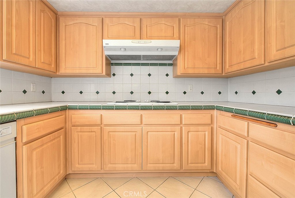 4408 Elder Avenue Seal Beach, CA 90740 - Photo 23 of 73 a kitchen with stainless steel appliances granite countertop white cabinets and a refrigerator with wooden floor