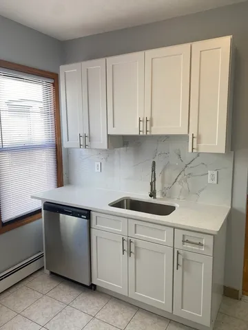 a kitchen with white cabinets and white appliances