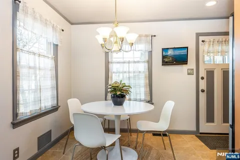 a view of a dining room with furniture a chandelier and wooden floor