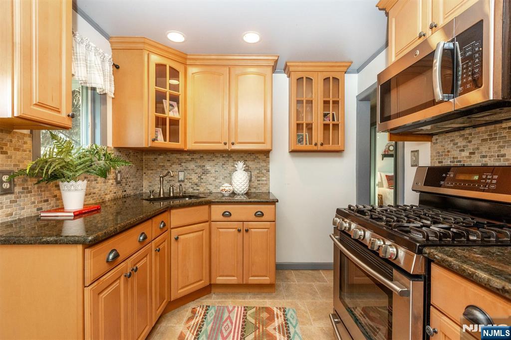 27 Gillespie Road Bloomfield, NJ 07003 - Photo 13 of 25 a kitchen with stainless steel appliances granite countertop a stove and a sink