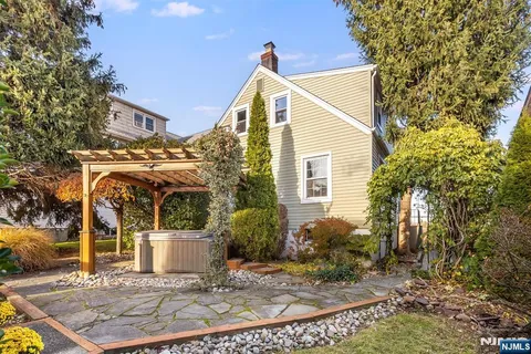 a view of a white house with a small yard and plants
