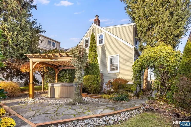 a view of a white house with a small yard and plants