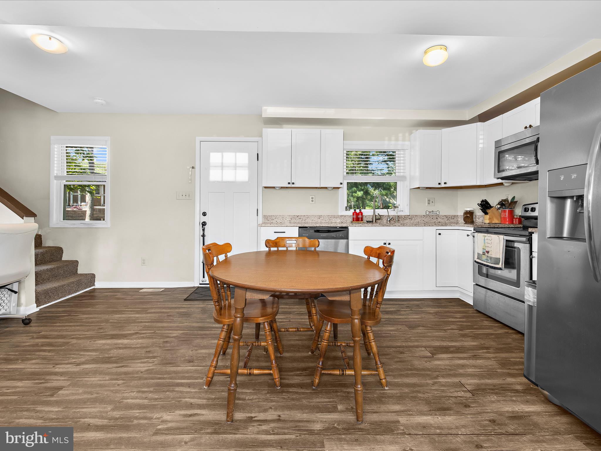 593 Riverside Drive Pasadena, MD 21122 - Photo 8 of 56 a kitchen with stainless steel appliances a dining table chairs and a refrigerator