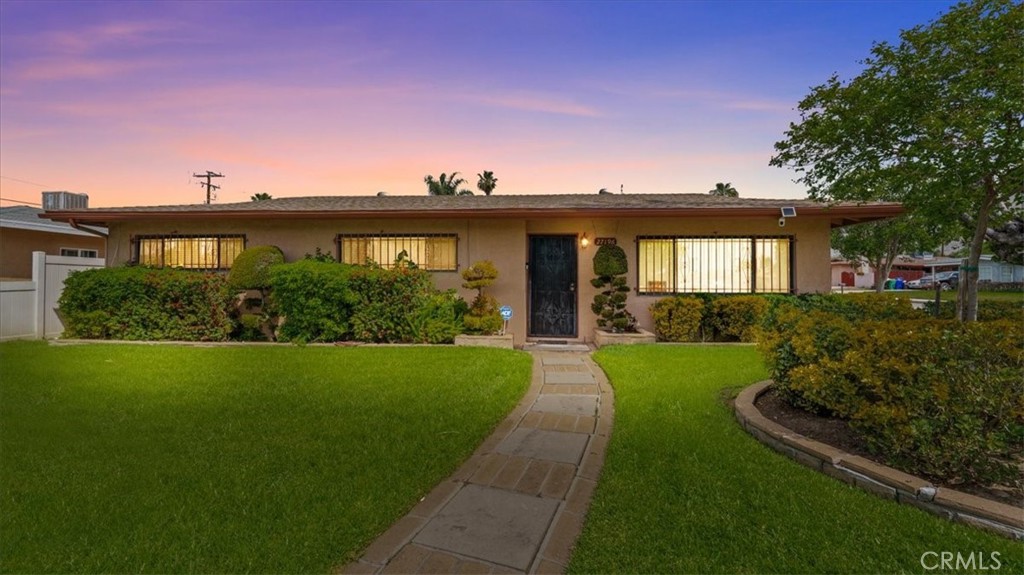 a view of a house with a yard and potted plants