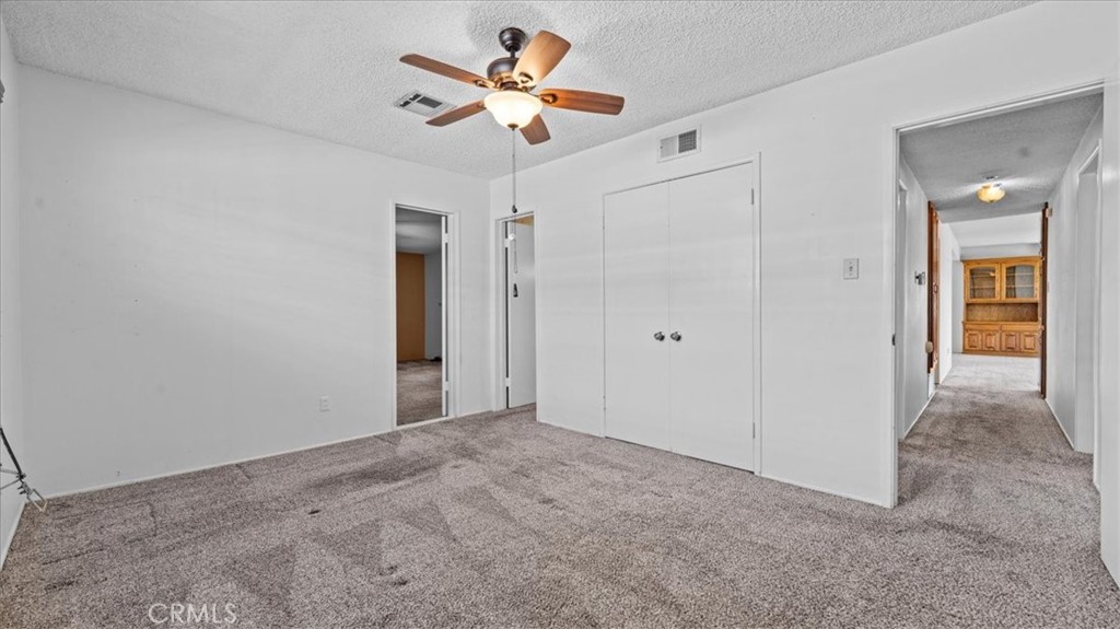 27196 10th Street Highland, CA 92346 - Photo 17 of 42 a view of a big room with closet and a chandelier fan