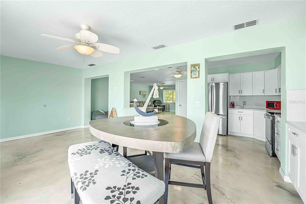3379 Crape Myrtle Drive Hernando Beach, FL 34607 - Photo 12 of 68 a dining room with wooden floor and chandelier