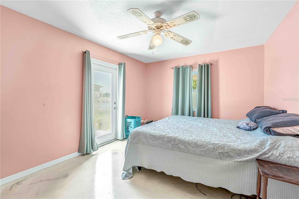 3379 Crape Myrtle Drive Hernando Beach, FL 34607 - Photo 22 of 68 a bedroom with a bed and a chandelier