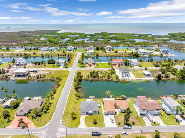 an aerial view of ocean and residential houses with outdoor space