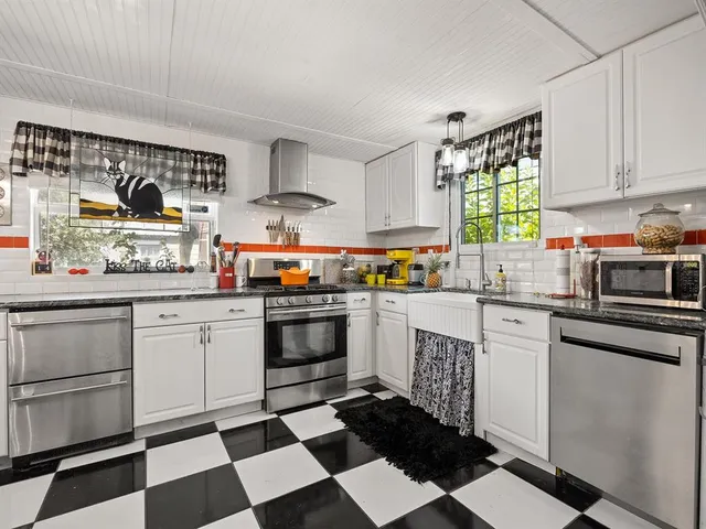 a kitchen with stainless steel appliances a stove a sink and a window