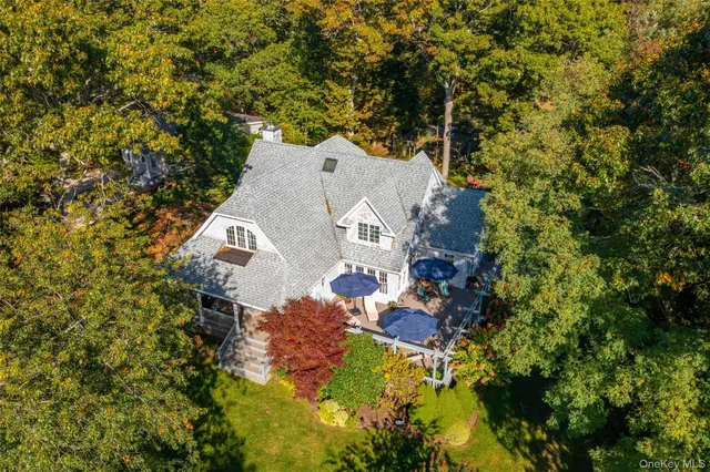 an aerial view of residential house with outdoor space and trees all around
