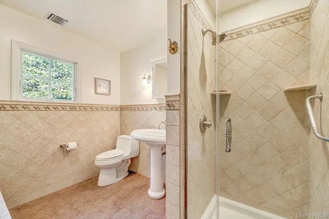 a bathroom with a white toilet and a shower