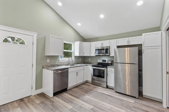 a kitchen with a refrigerator sink and stove top oven