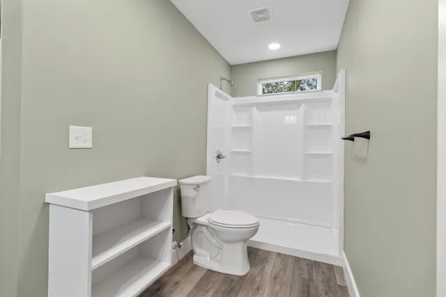 a bathroom with a toilet and a shower