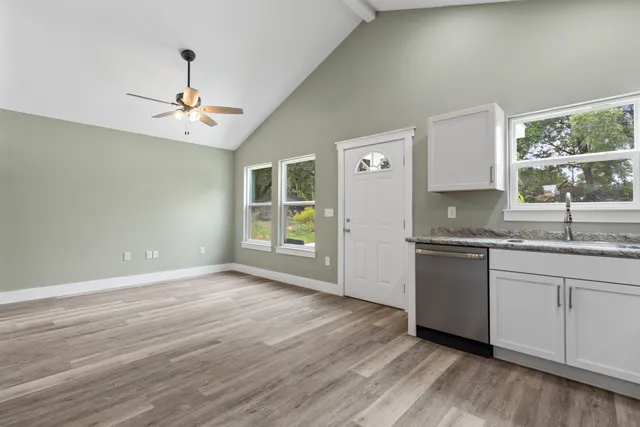 a kitchen with granite countertop a stove a sink and a refrigerator