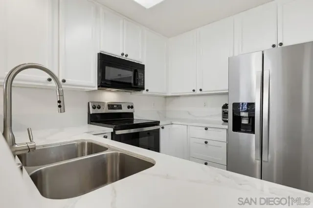 a kitchen with a sink and steel appliances