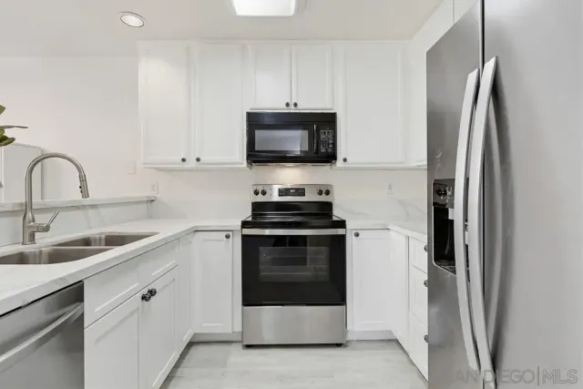 a kitchen with stainless steel appliances a stove microwave and a sink