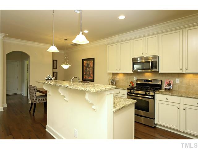 2327 Lowden Street Raleigh, NC 27608 - Photo 8 of 25 a kitchen with stainless steel appliances granite countertop a sink a stove top oven a chimney and a center island
