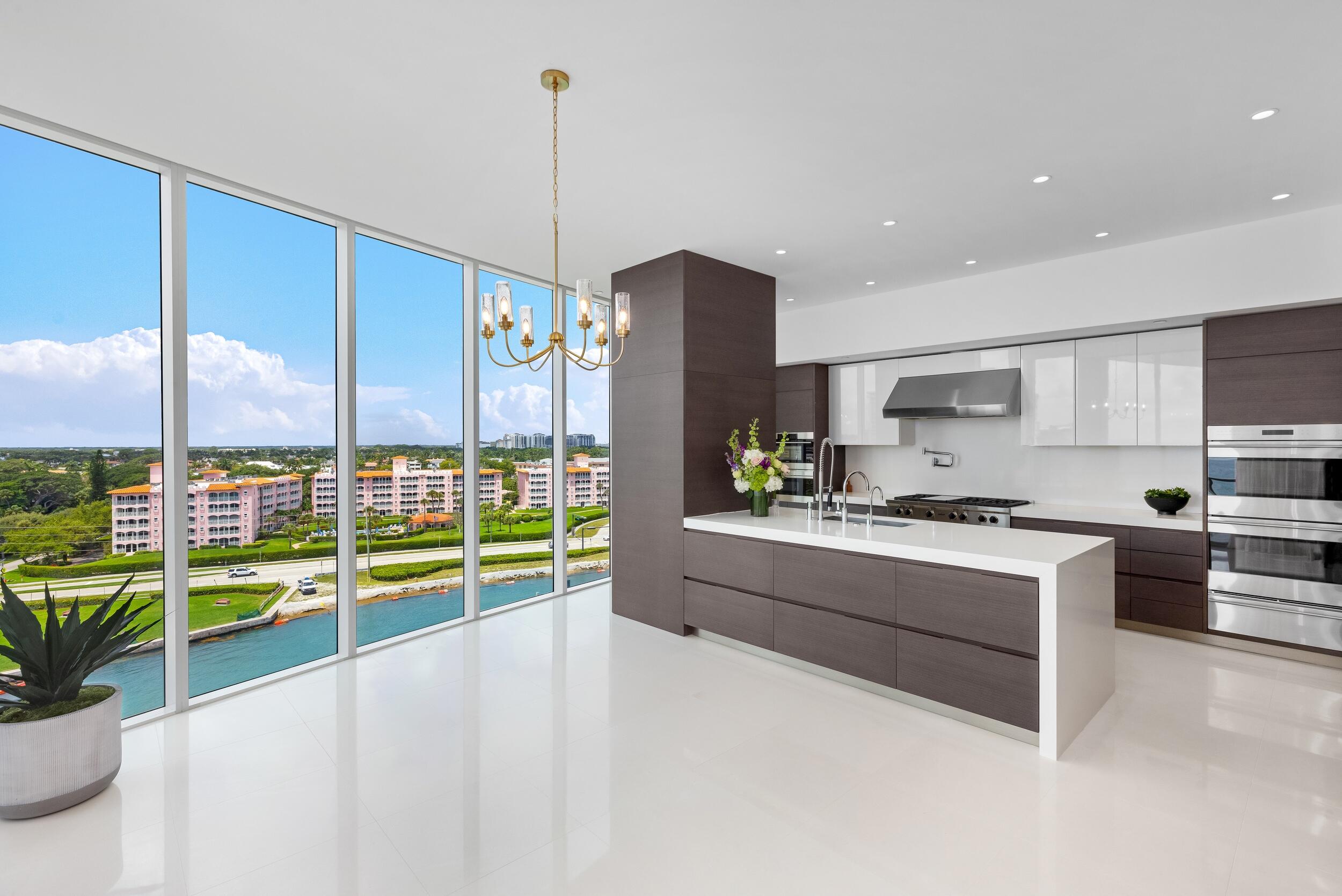 1000 South Ocean Boulevard, Unit 601 Boca Raton, FL 33432 - Photo 12 of 54 a kitchen with stainless steel appliances kitchen island wooden cabinets and white view of living room