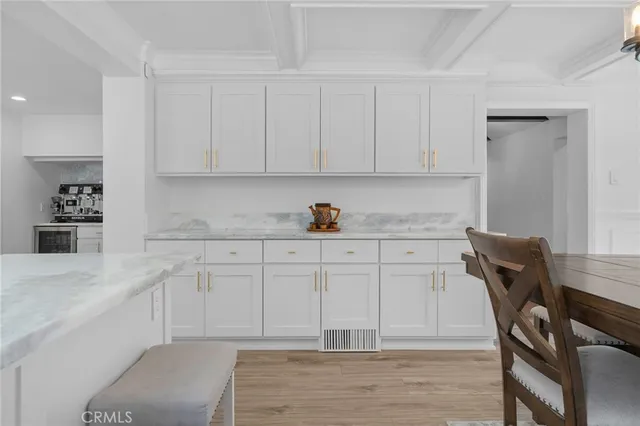 a kitchen with stainless steel appliances granite countertop a sink a stove and white cabinets with wooden floor