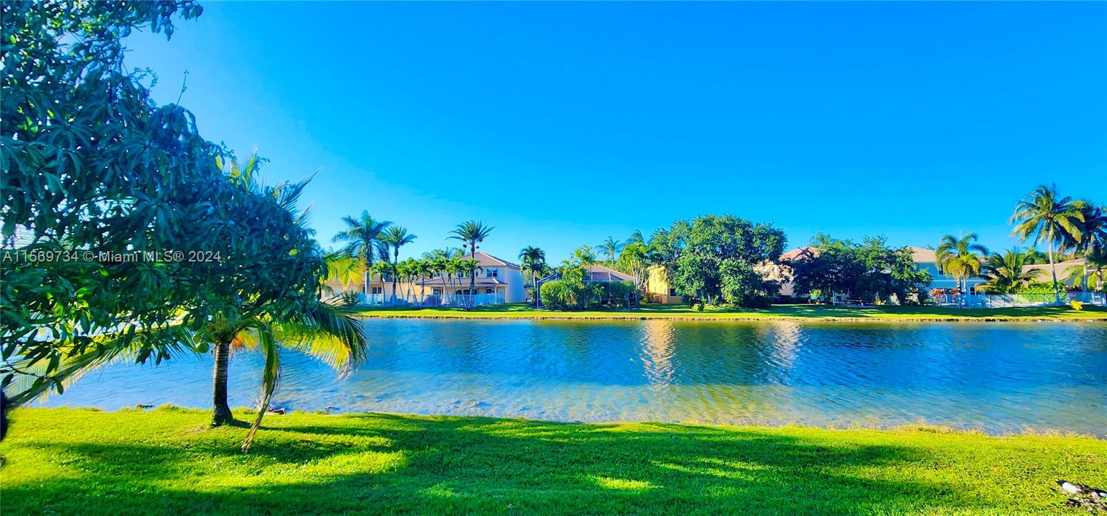 16519 Ruby Lake, Unit 16519 Weston, FL 33331 - Photo 19 of 24 a view of a lake with a house in the background