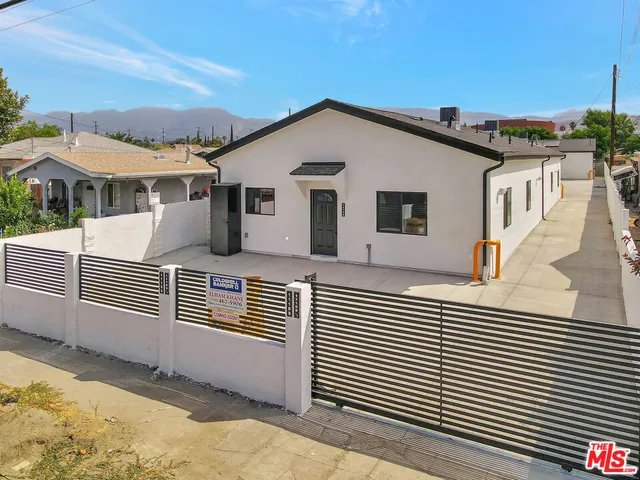 a view of a house with a wooden fence