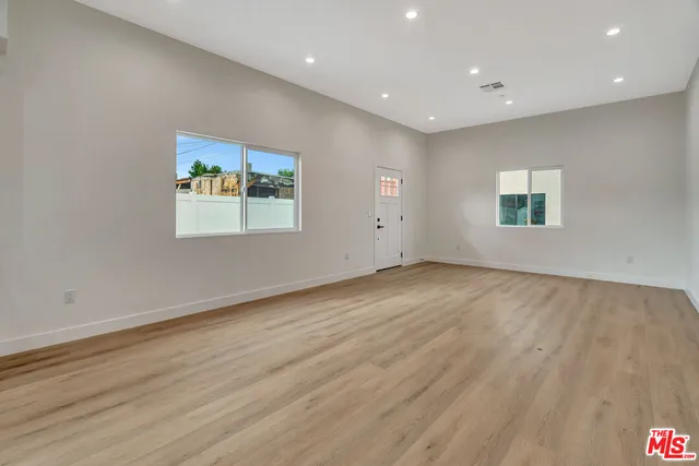 a kitchen with a refrigerator and white cabinets