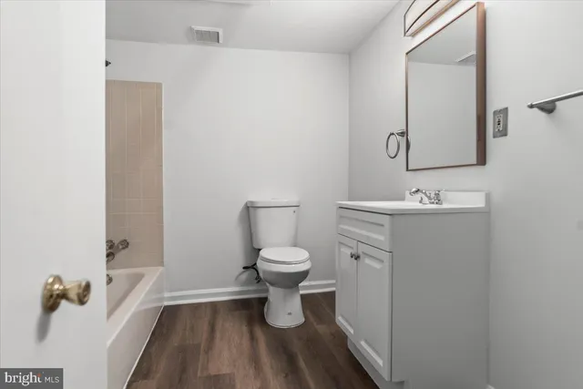 a bathroom with a granite countertop toilet a sink and a mirror