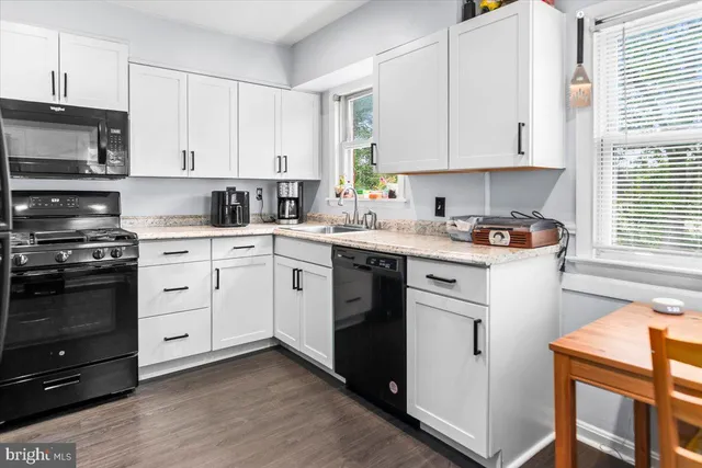 a kitchen with cabinets appliances a sink and a window