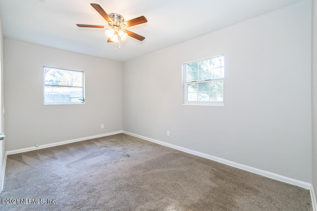 7263 Melvin Road Jacksonville, FL 32210 - Photo 8 of 15 an empty room with windows and fan