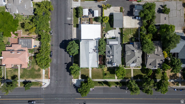 299 West Center Street, Unit 2 Logan, UT 84321 - Photo 46 of 46 Aerial perspective showcasing a residential property with a light-colored roof, surrounded by mature trees and paved surfaces