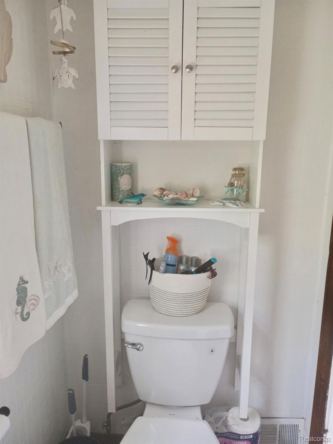 11063 Jackson Street Taylor, MI 48180 - Photo 16 of 27 White louvered cabinet over toilet with open shelf storage