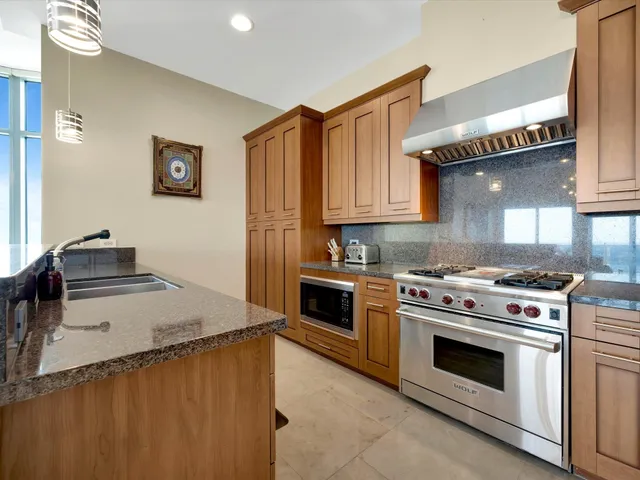 a kitchen with granite countertop a stove and a sink