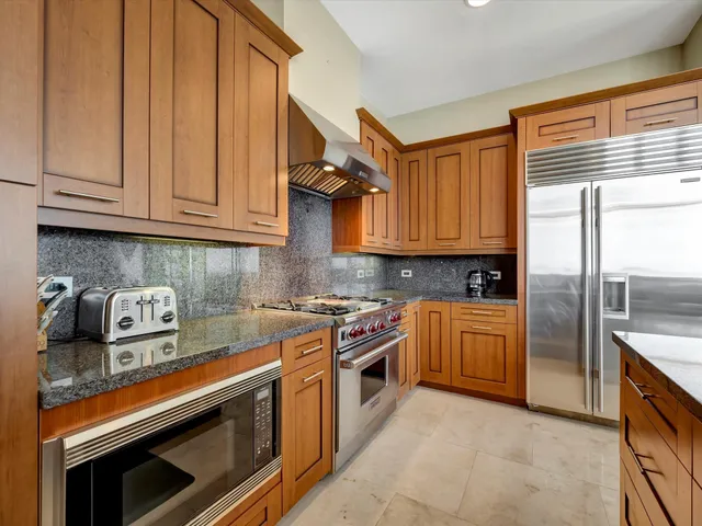 a kitchen with stainless steel appliances granite countertop a stove a sink and a refrigerator