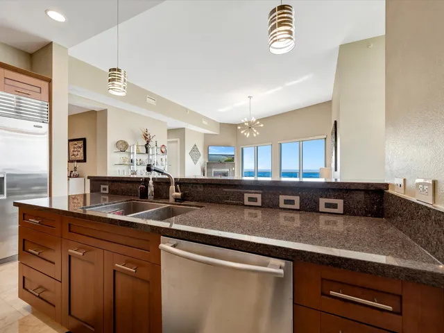 a kitchen with granite countertop a sink a stove and a granite counter top