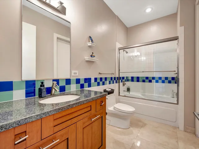 a bathroom with a granite countertop sink mirror vanity and toilet