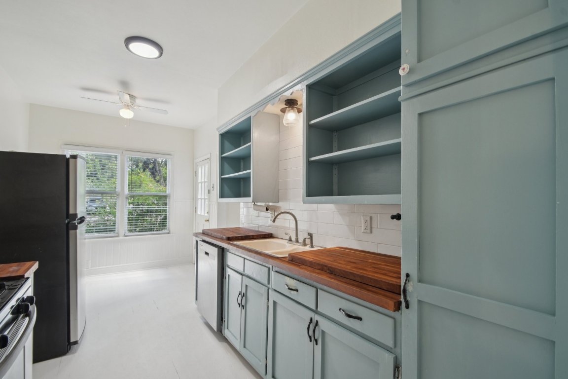 308 Taylor Road Elgin, TX 78621 - Photo 15 of 29 Kitchen with butcher block counters, ceiling fan, tasteful backsplash, open shelves, and appliances with stainless steel finishes