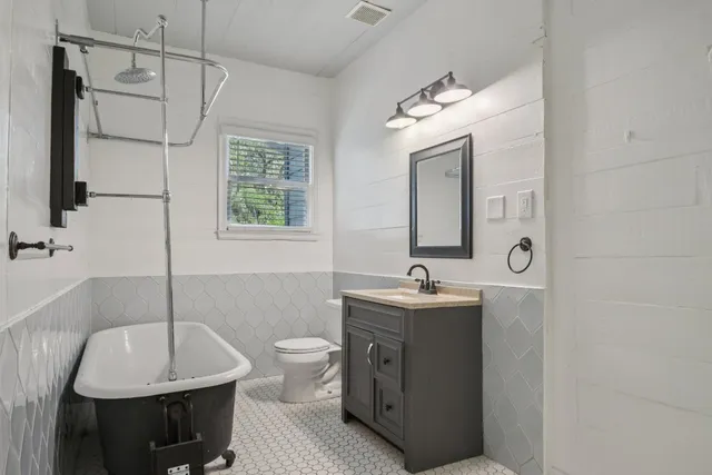 a bathroom with a double vanity sink a mirror and a bathtub