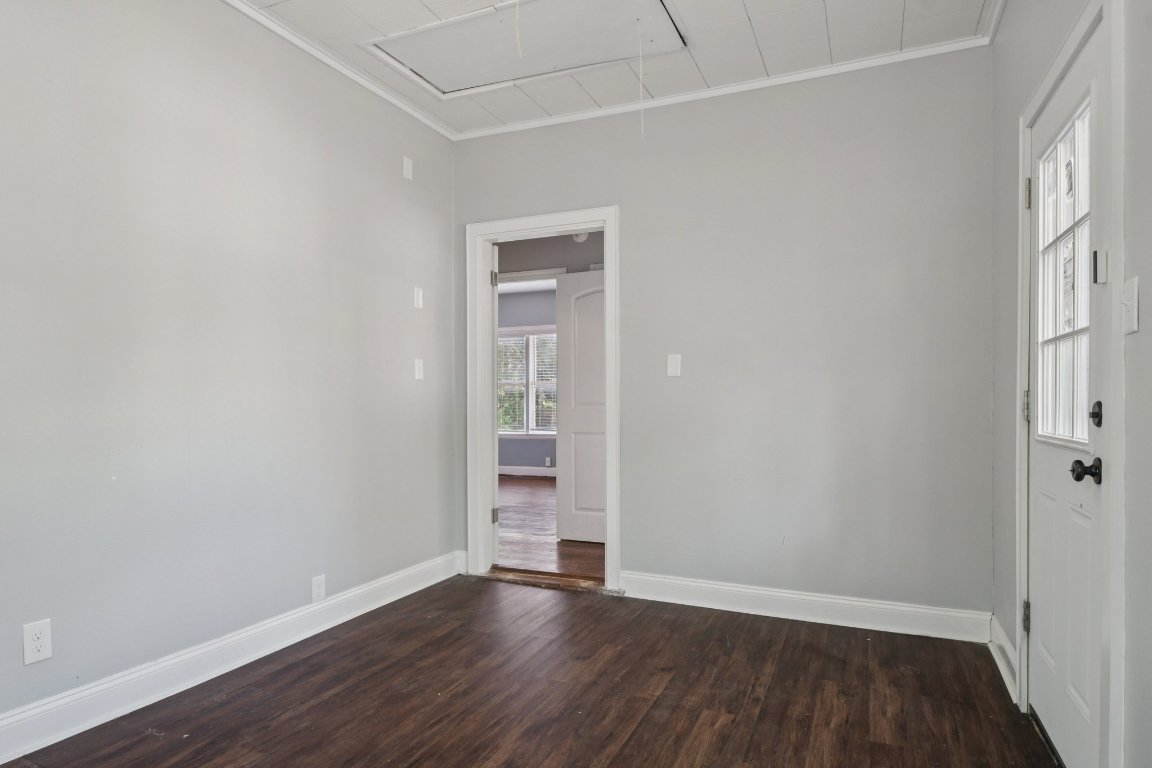 308 Taylor Road Elgin, TX 78621 - Photo 25 of 29 Spare room featuring attic access, dark wood-type flooring, and ornamental molding