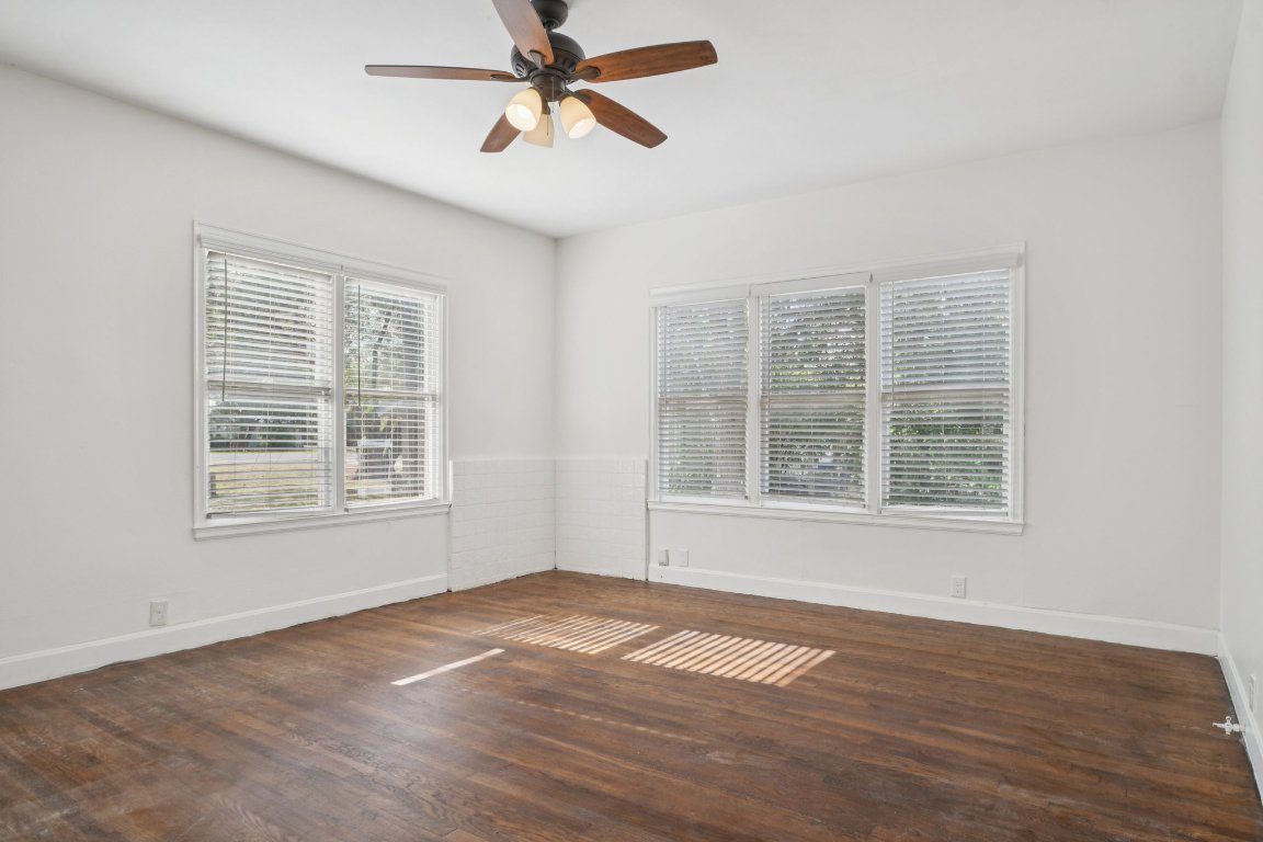 308 Taylor Road Elgin, TX 78621 - Photo 5 of 29 Empty room with healthy amount of natural light, dark wood-style flooring, and ceiling fan