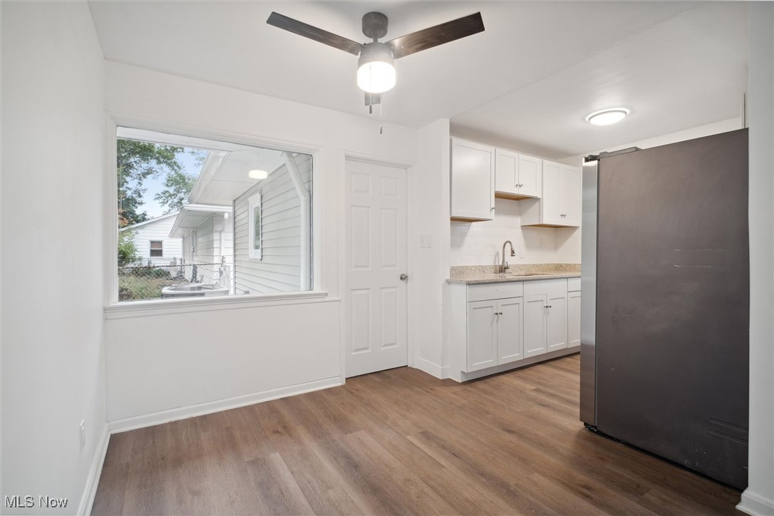 8796 West Ridgewood Drive Cleveland, OH 44130 - Photo 14 of 38 Kitchen with stainless steel fridge, white cabinets, ceiling fan, light hardwood / wood-style flooring, and sink