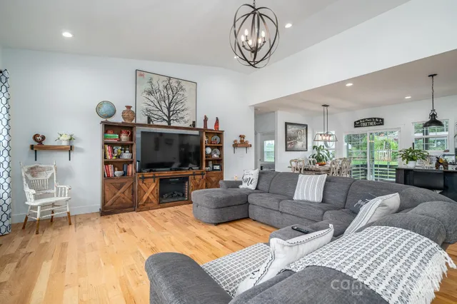 a living room with furniture a flat screen tv and kitchen view