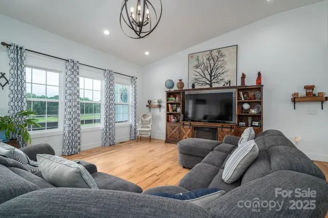 a living room with furniture a flat screen tv and a large window