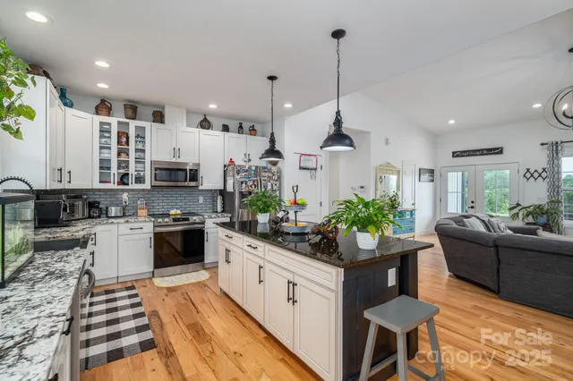 a kitchen with stainless steel appliances kitchen island granite countertop a stove a sink and a refrigerator